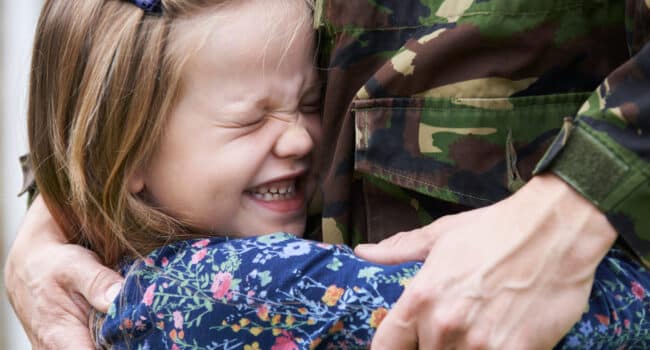 Soldier being hugged by daughter